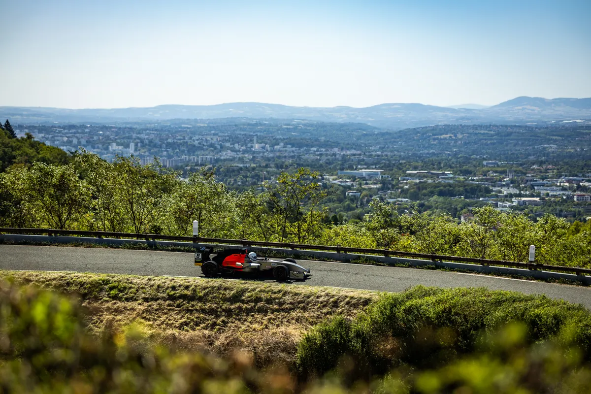 Panorama du paysage autour du tracé de la course avec monoplace noire en bas de la photo