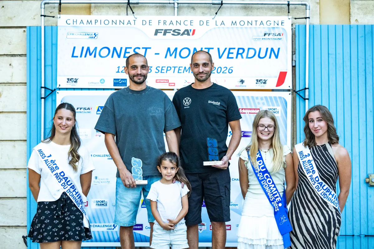 Texte et trophées devant un mur publicitaire avec plusieurs personnes posant